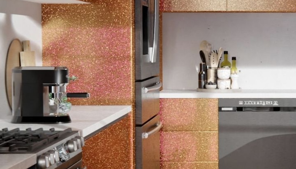 Cuisine moderne étincelante avec meubles à paillettes dorées et roses, machine à café et électroménagers noirs.